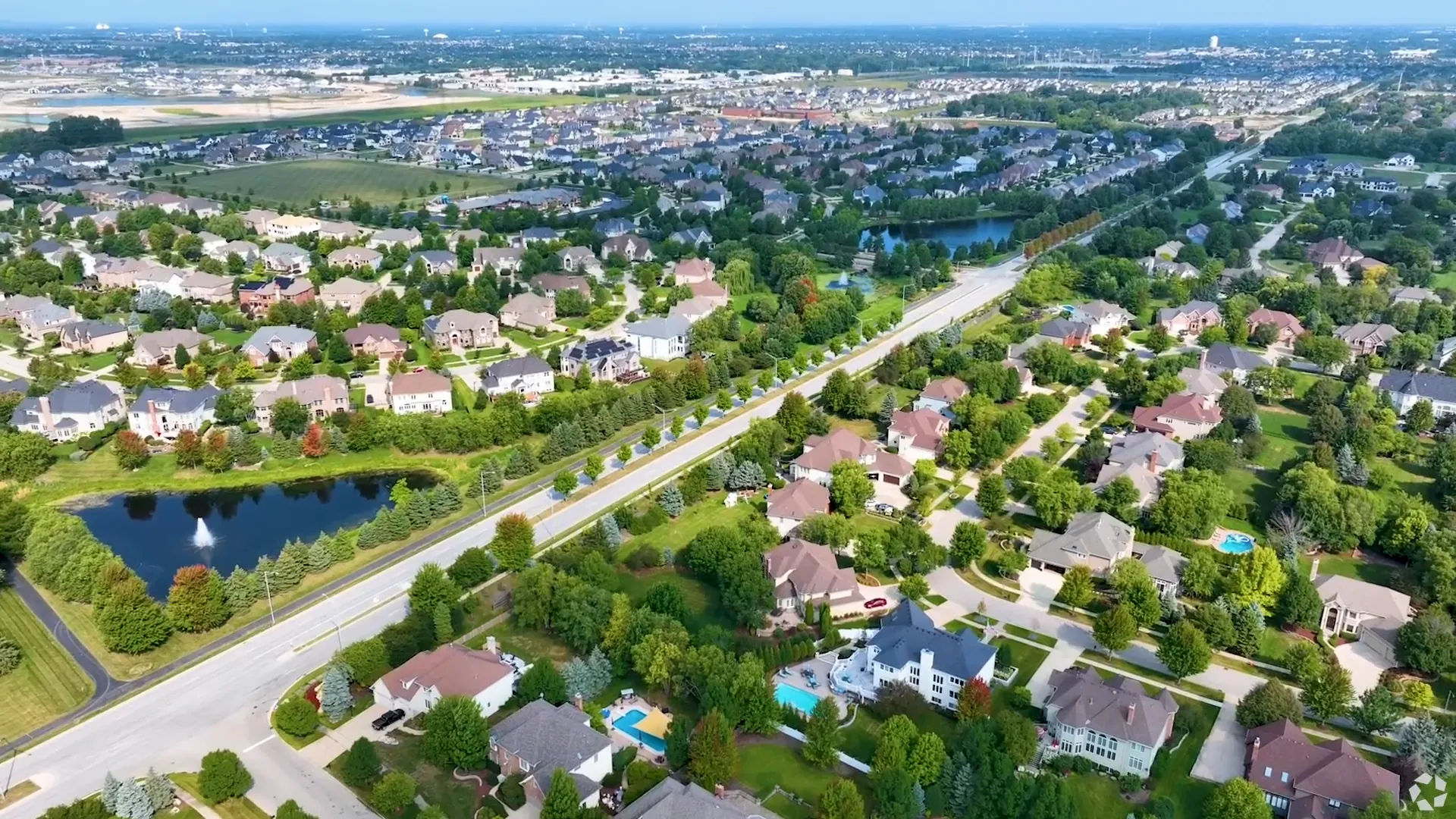Aerial view of Naperville's tree-lined neighborhoods and downtown
